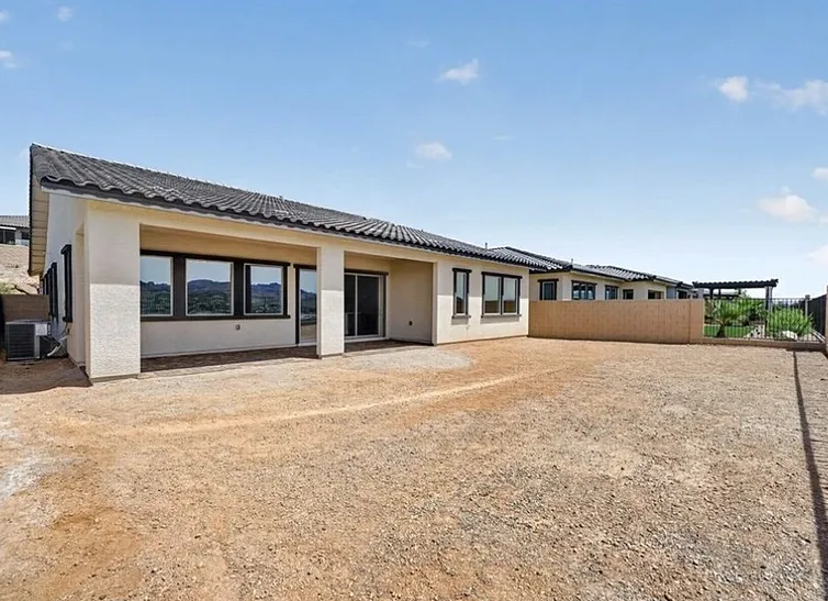 Bare backyard with dirt and no landscaping